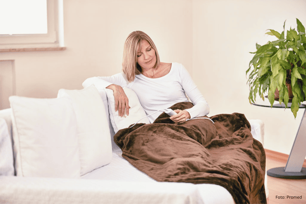 Ältere Frau mit Wärmeheizdecke