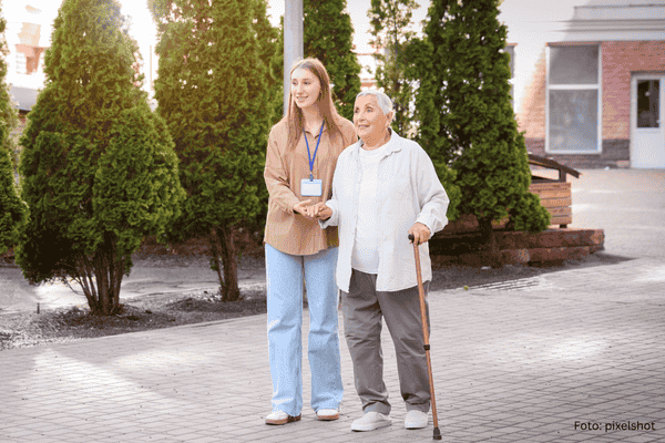Seniorin mit Gehilfe und Pflegerin 