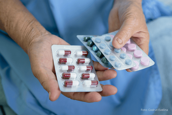 Antobiotikum hilft bei Blasenentzündung Mann - älterer Mann hält Habletten in der Hand